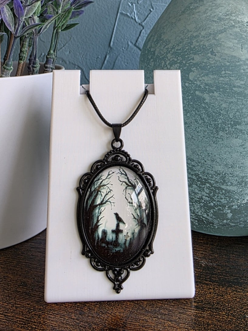 Antique pendant necklace with image of crow in a grave yard gothic mystic
