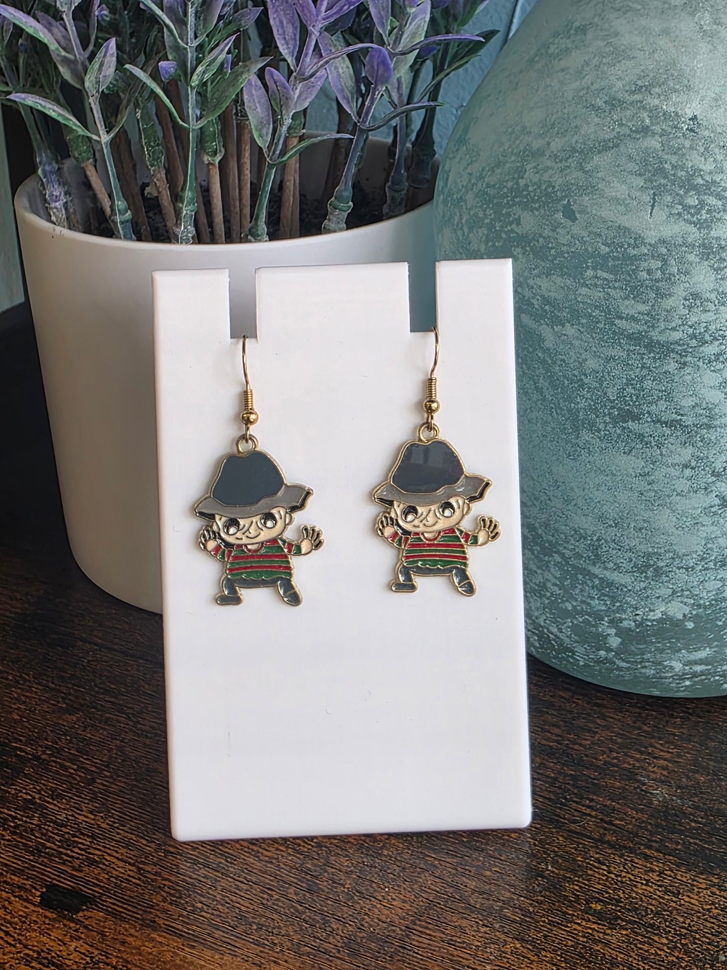 Earrings depicting cartoon Freddy Krueger character.
