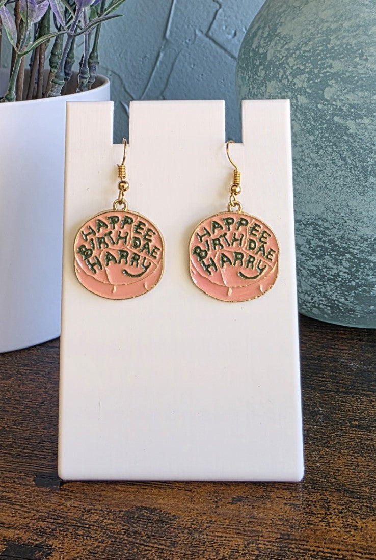 Harry Potter earrings featuring Hagrid's birthday cake to Harry. Happee Birthdae Harry