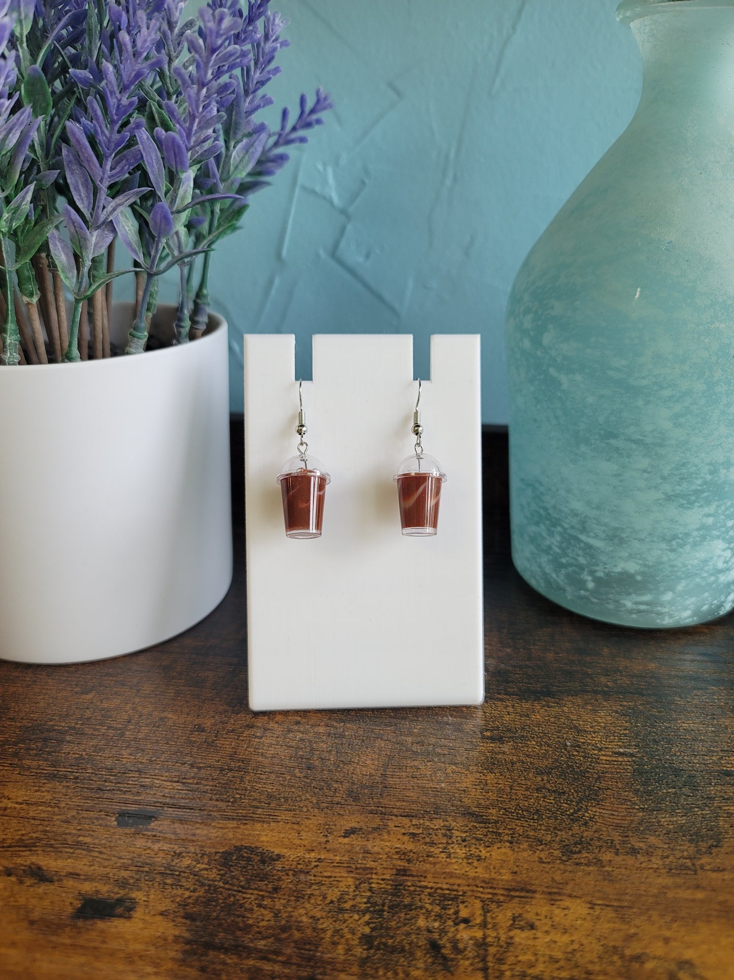 Pair of earrings on a white card with a decorative background