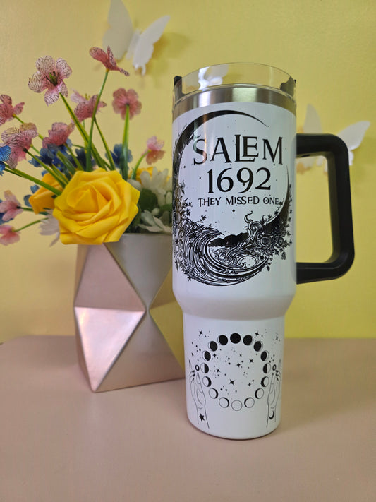 Salem Witch Trials tumbler on a pink surface with yellow background