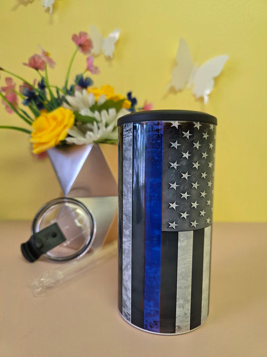 Insulated 4‑in‑1 stainless steel tumbler featuring torn‑metal American flag design, shown with lid and floral arrangement