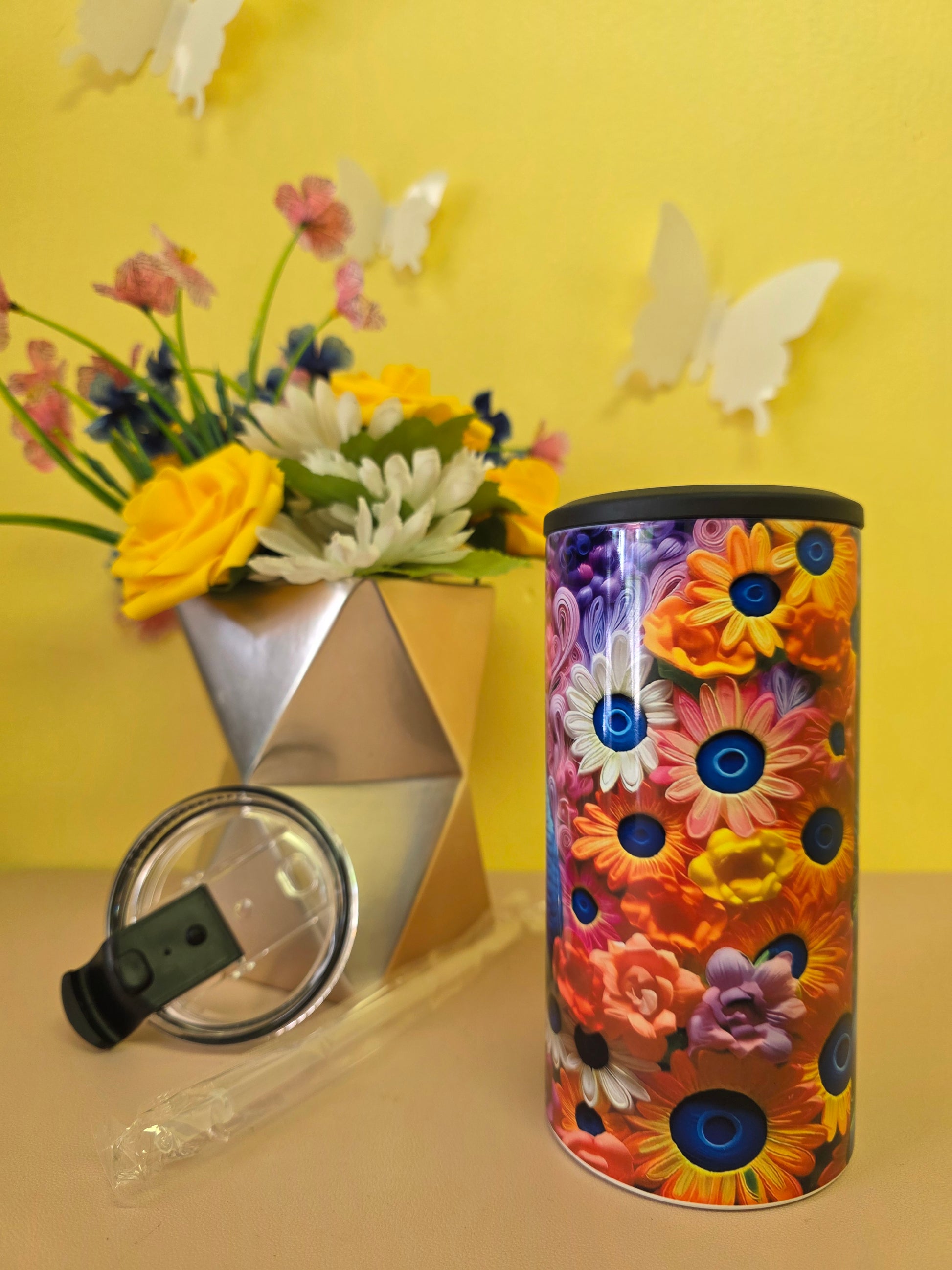 Insulated 4‑in‑1 stainless steel tumbler with vibrant multicolor floral design, shown with lid, straw, and flower arrangement