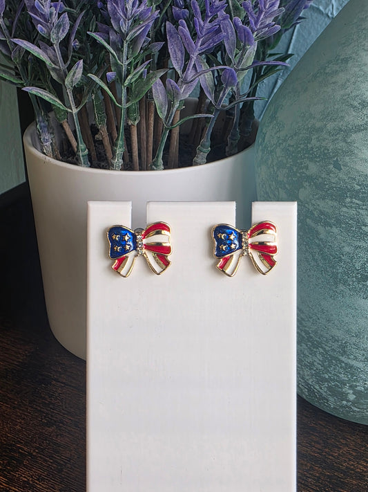 Pair of bow-shaped earrings with red, white, and blue design on a white surface Independence Day