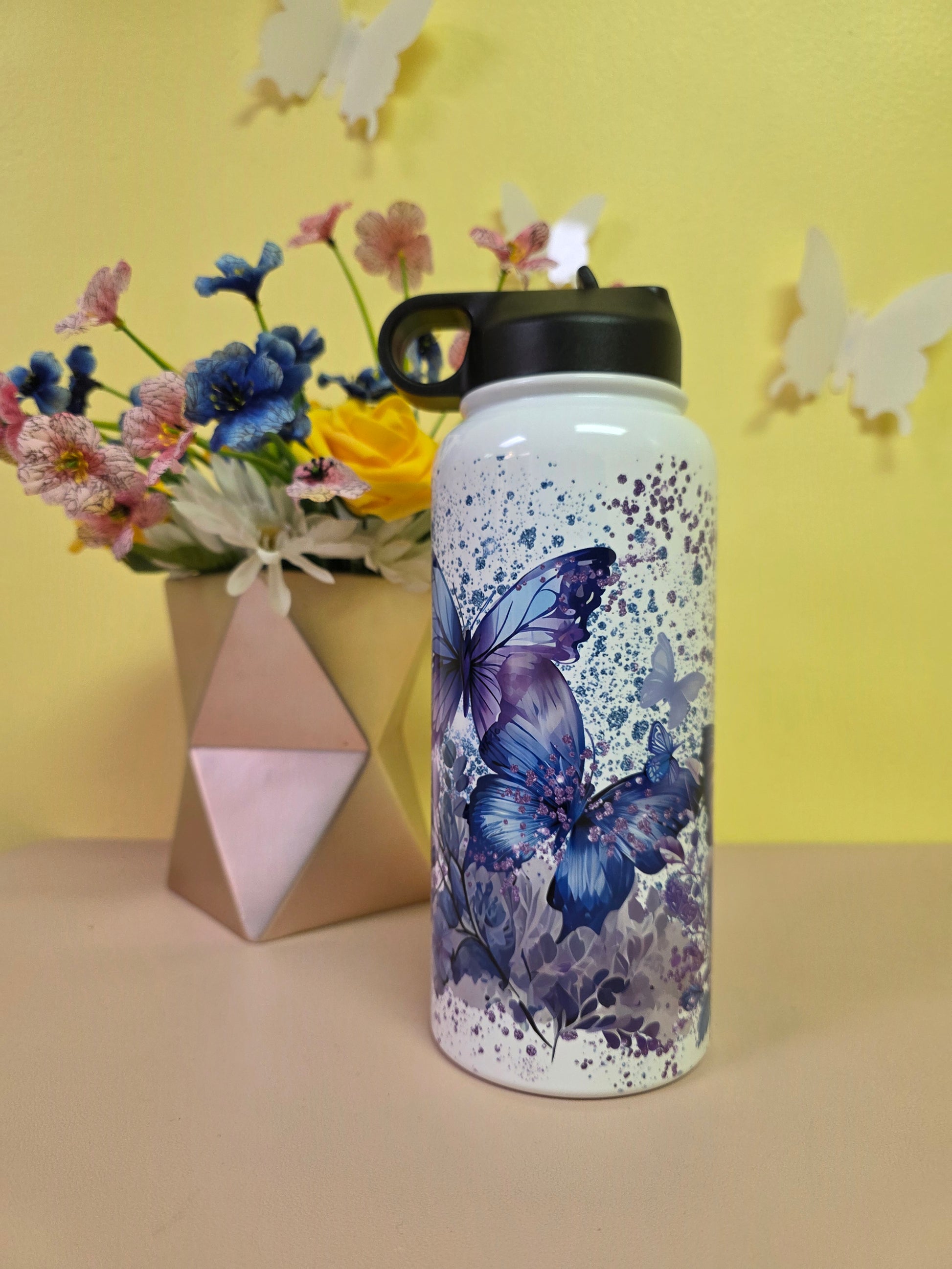 Water bottle with butterfly design on a yellow background