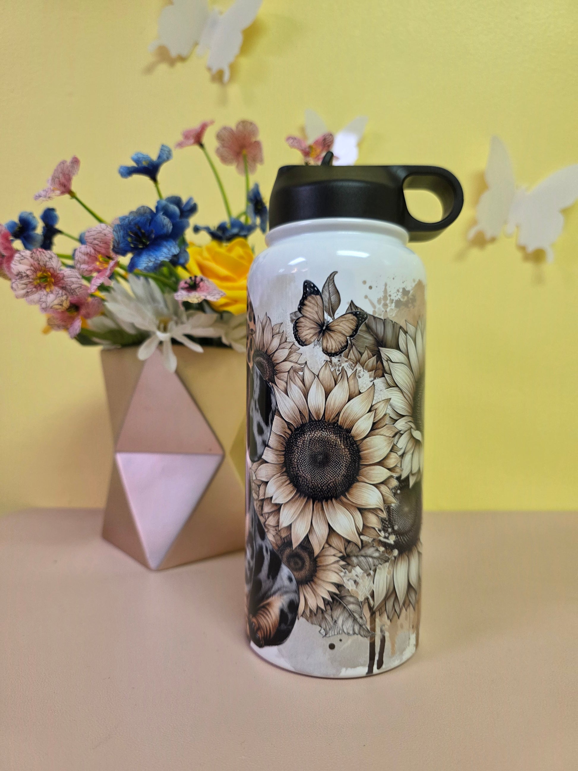 Floral-patterned water bottle on a yellow background with flowers and geometric shapes.