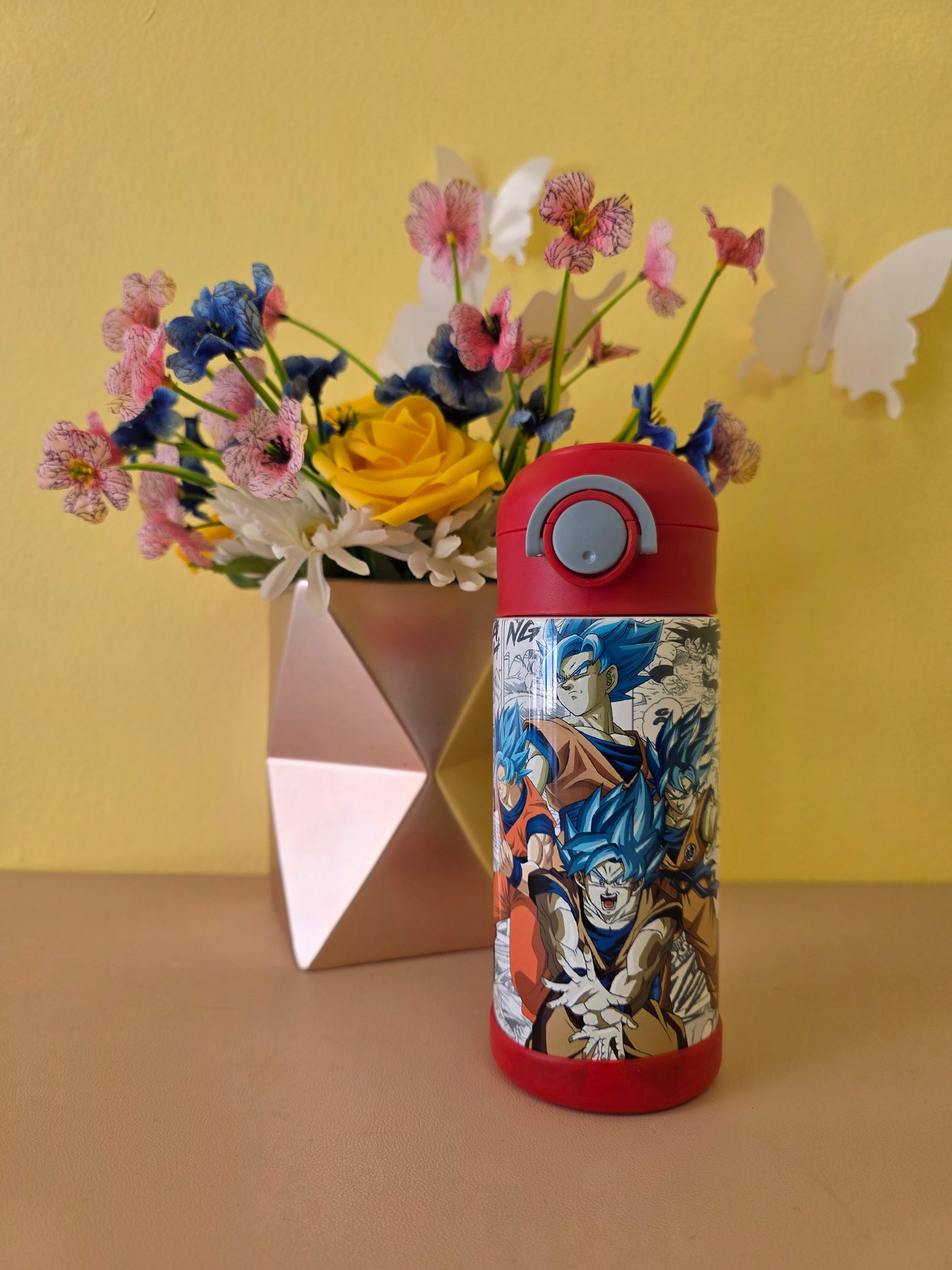 Dragon Ball Z tumbler on a table with flowers in the background. 