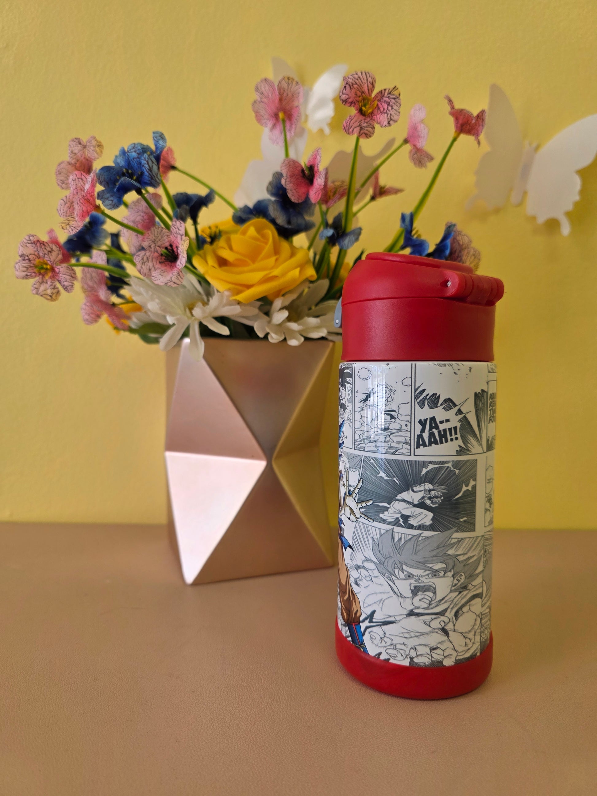 Dragon Ball Z tumbler on a table with flowers in the background. 
