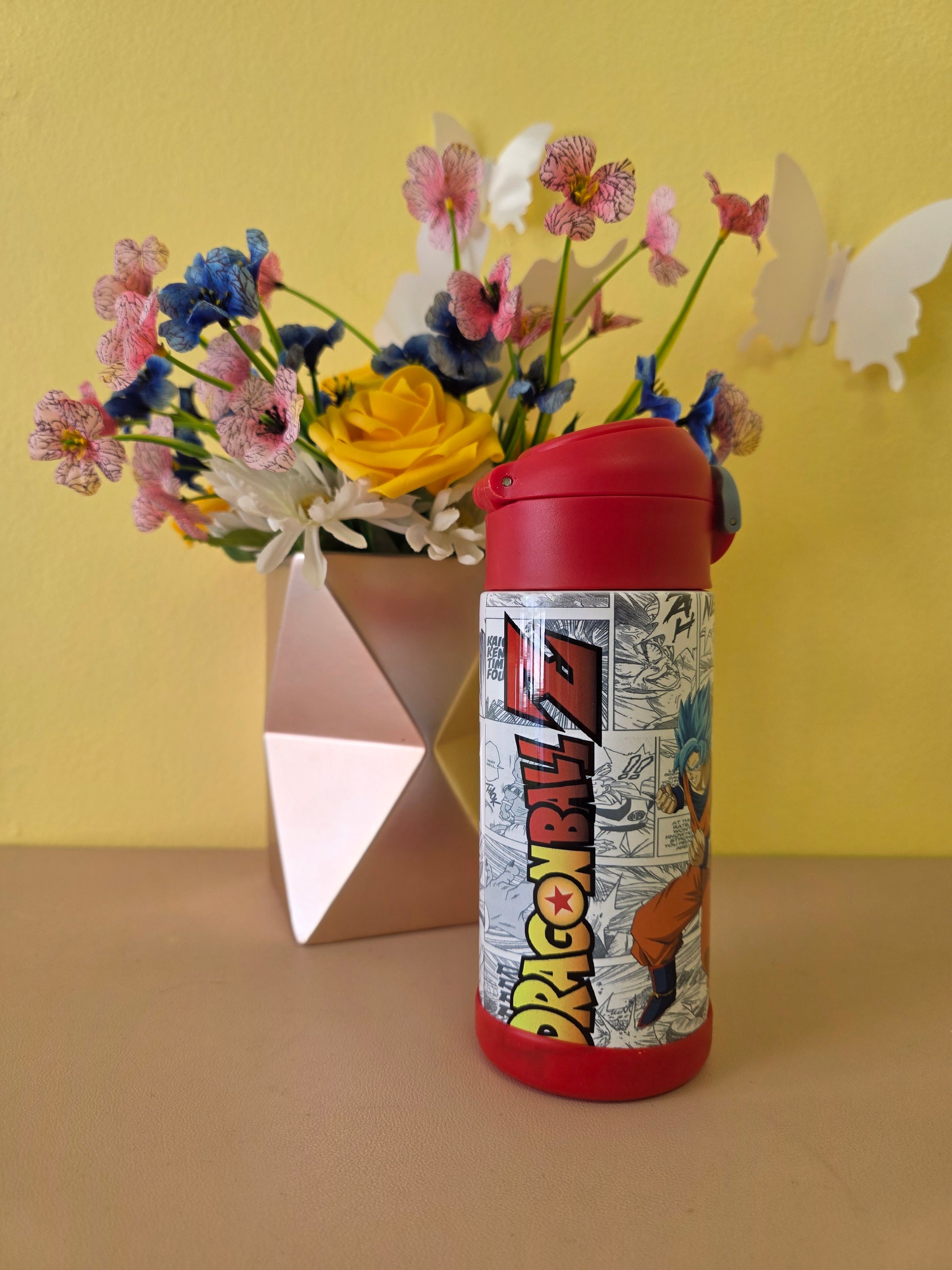 Dragon Ball Z tumbler on a table with flowers in the background. 