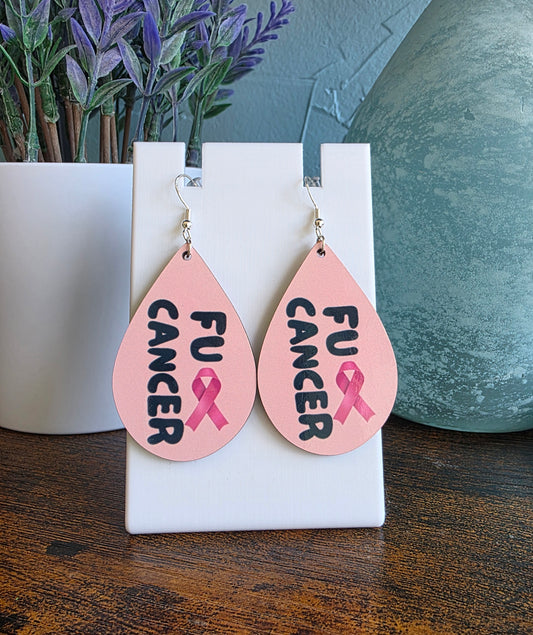 Teardrop-shaped earrings with 'FU CANCER' and pink ribbon design on a white stand.