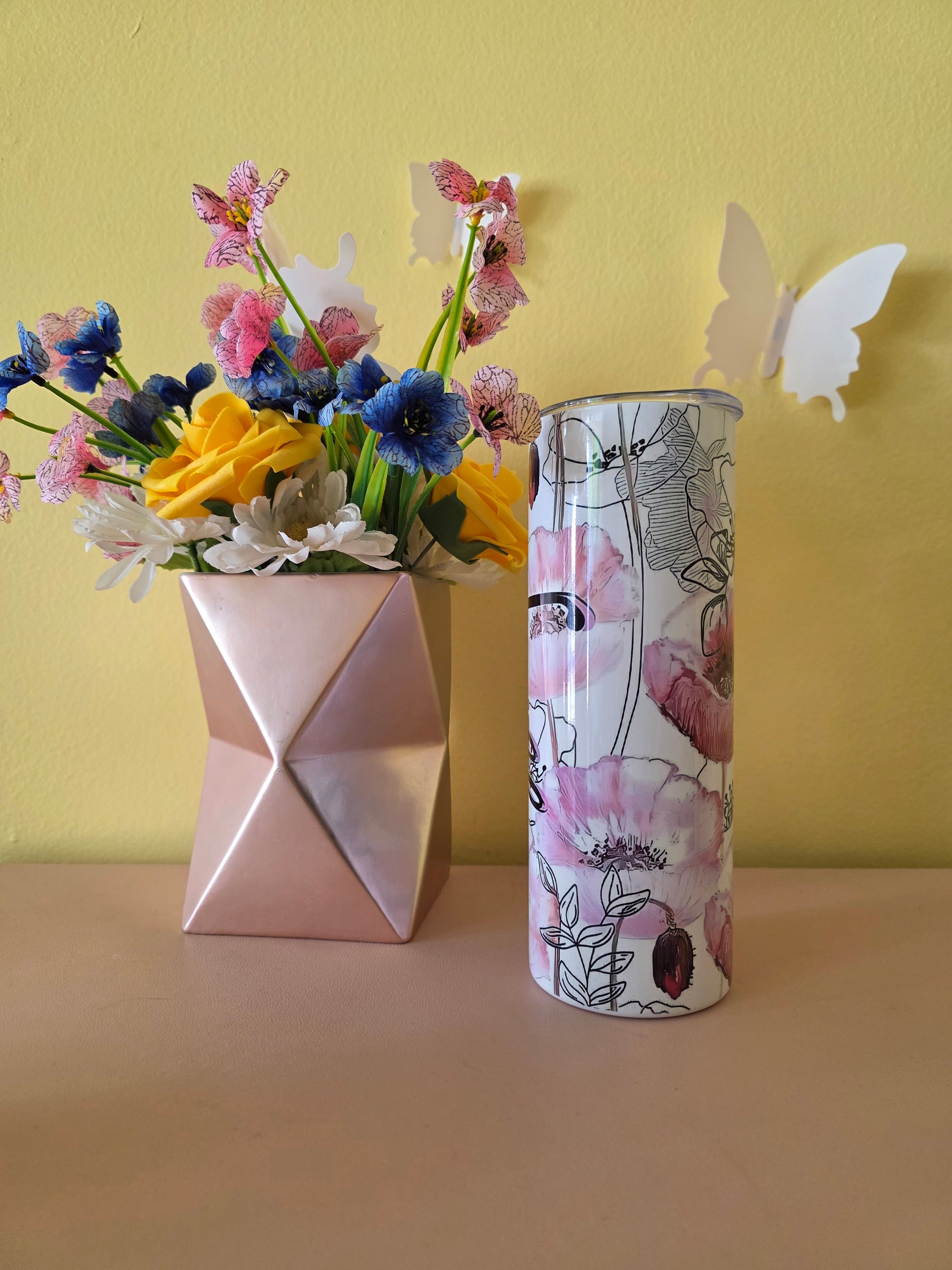 Decorative tumbler with 'Faith' text, colorful flowers, and a butterfly on a yellow background