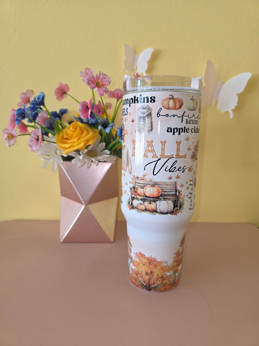 Fall Vibes 40 ounce tumbler on a pink table with yellow background