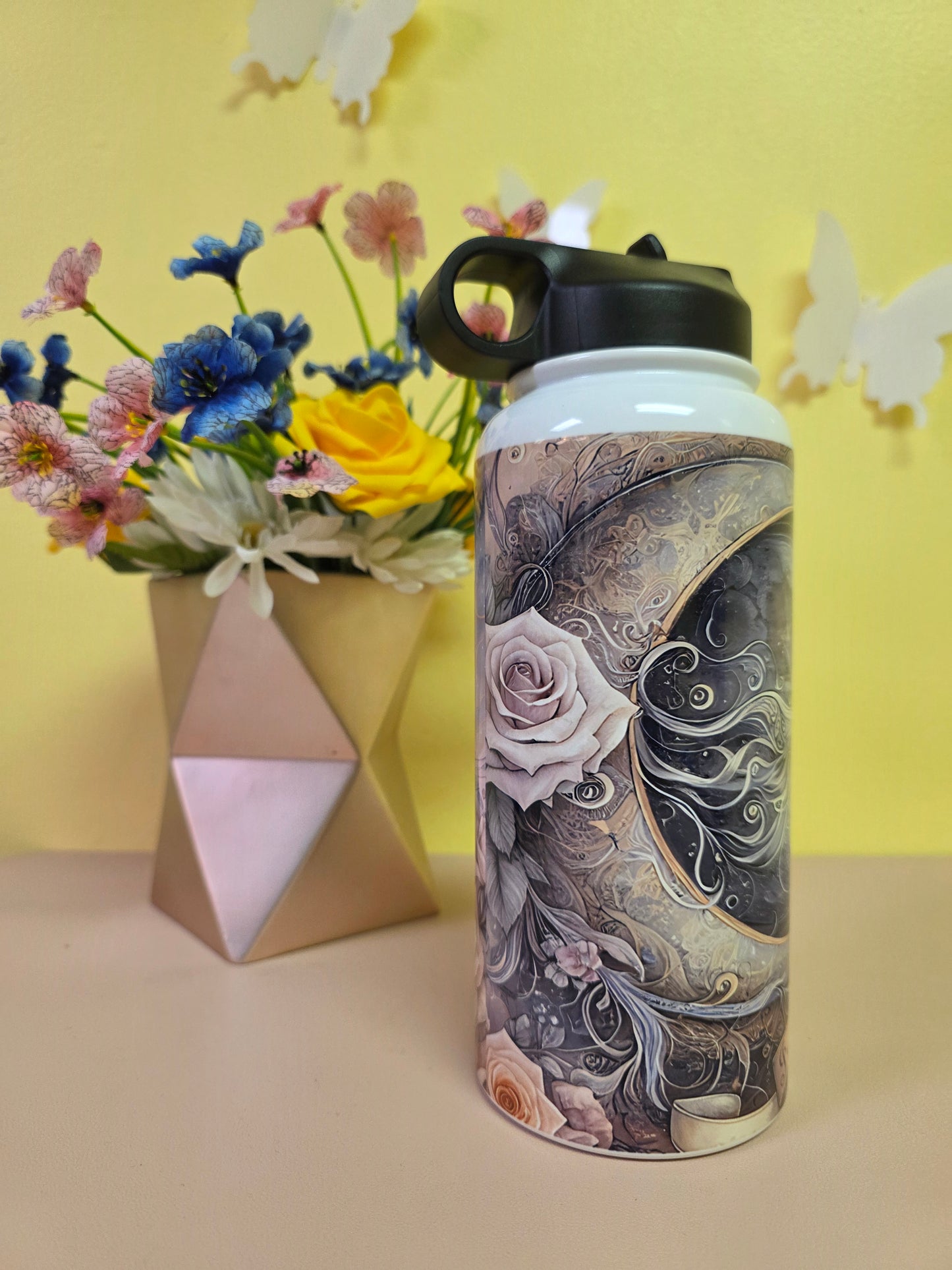 Tumbler with floral design on a yellow background with flowers and a box.