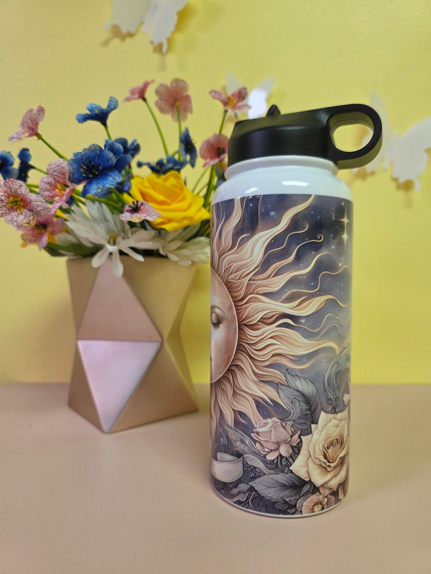 Decorative water bottle with artistic design on a yellow background