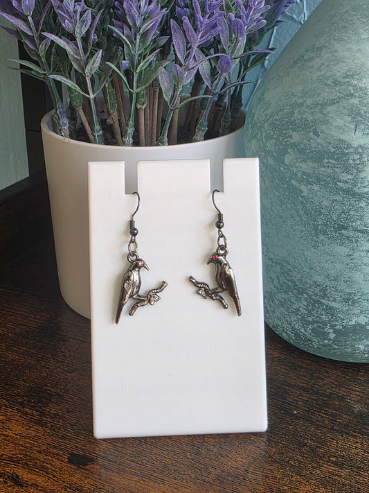 Pair of earrings of a black raven holding branch