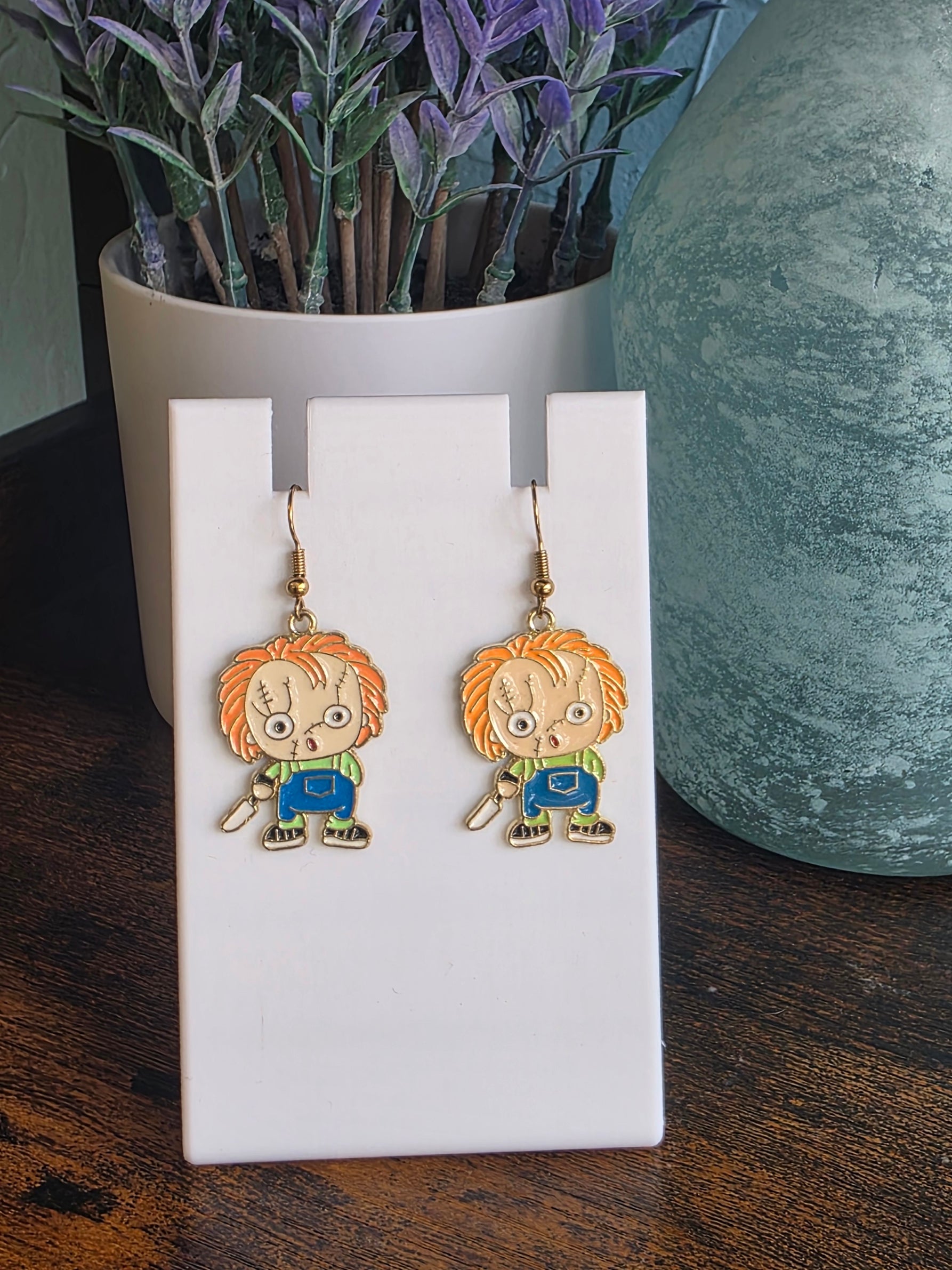 Pair of earrings depicting cartoon Chucky/Child's Play character.