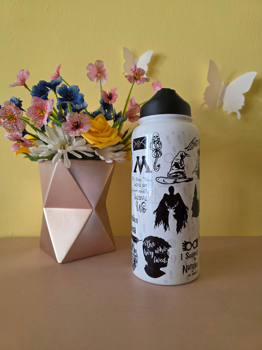 Harry Potter themed stainless steel water bottle on a table with yellow background