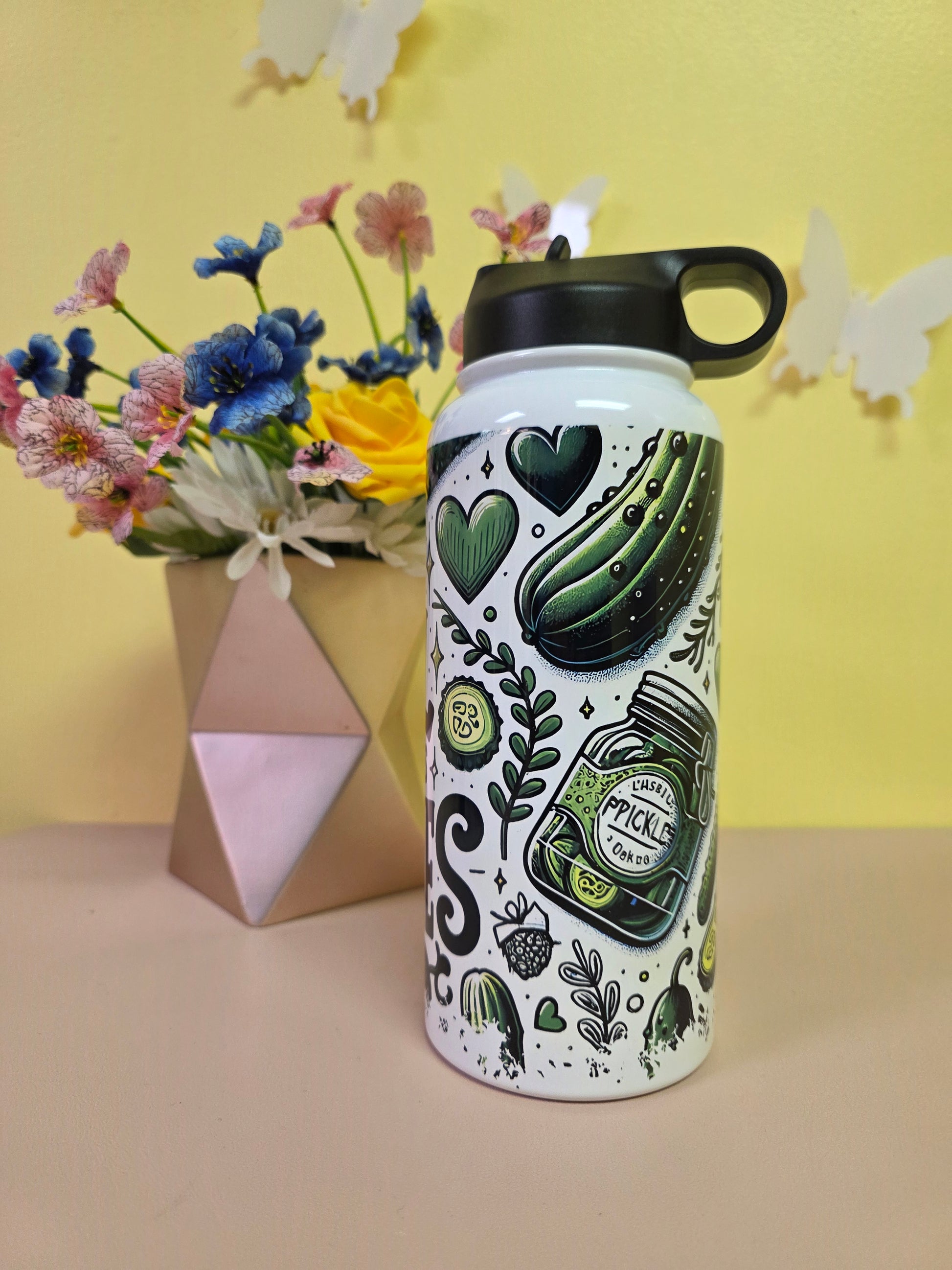 Decorative water bottle with green designs on a yellow and beige background