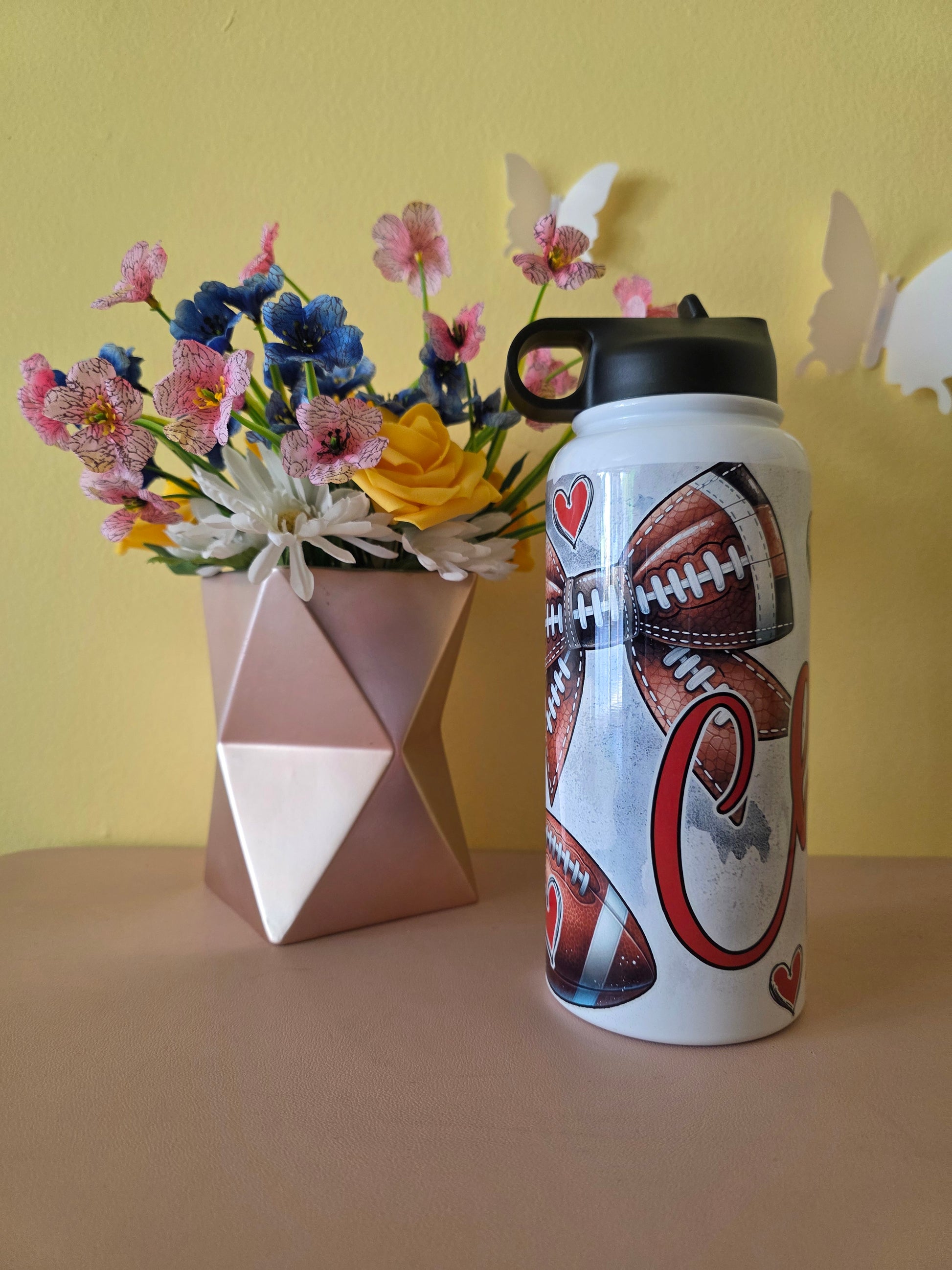 Kansas City Chiefs Football water bottle on a table with yellow background