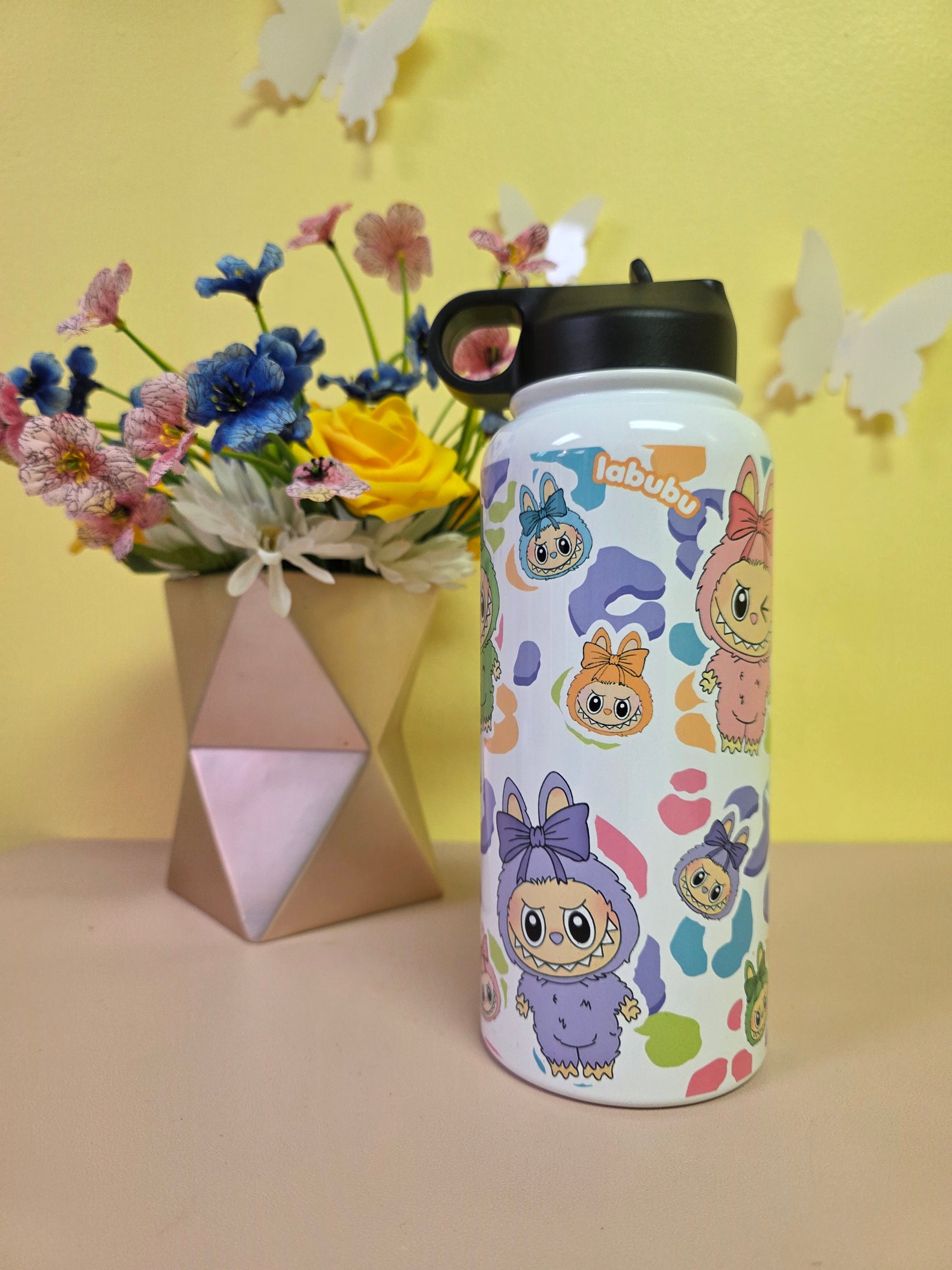 Colorful cartoon-patterned water bottle with flowers and a box on a yellow background
