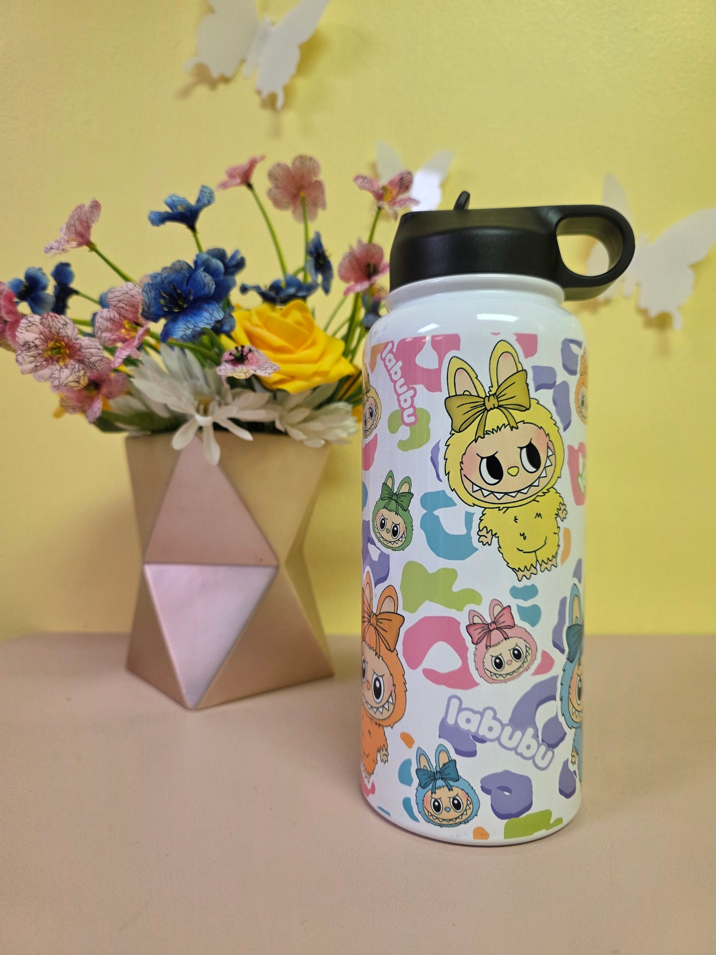 Colorful water bottle with cartoon characters on a yellow background