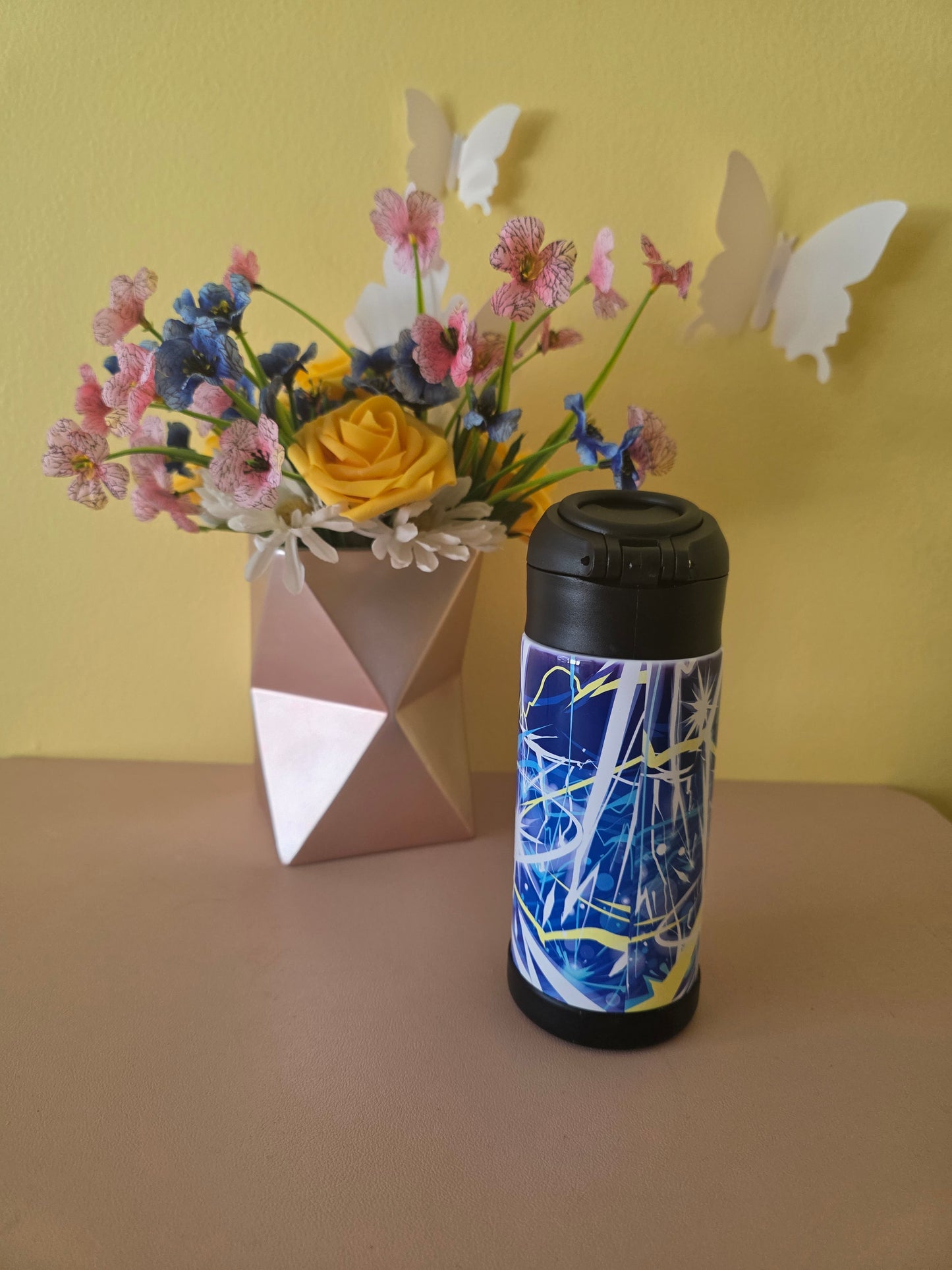 Pokemon Pikachu water bottle on a table with flowers in the background