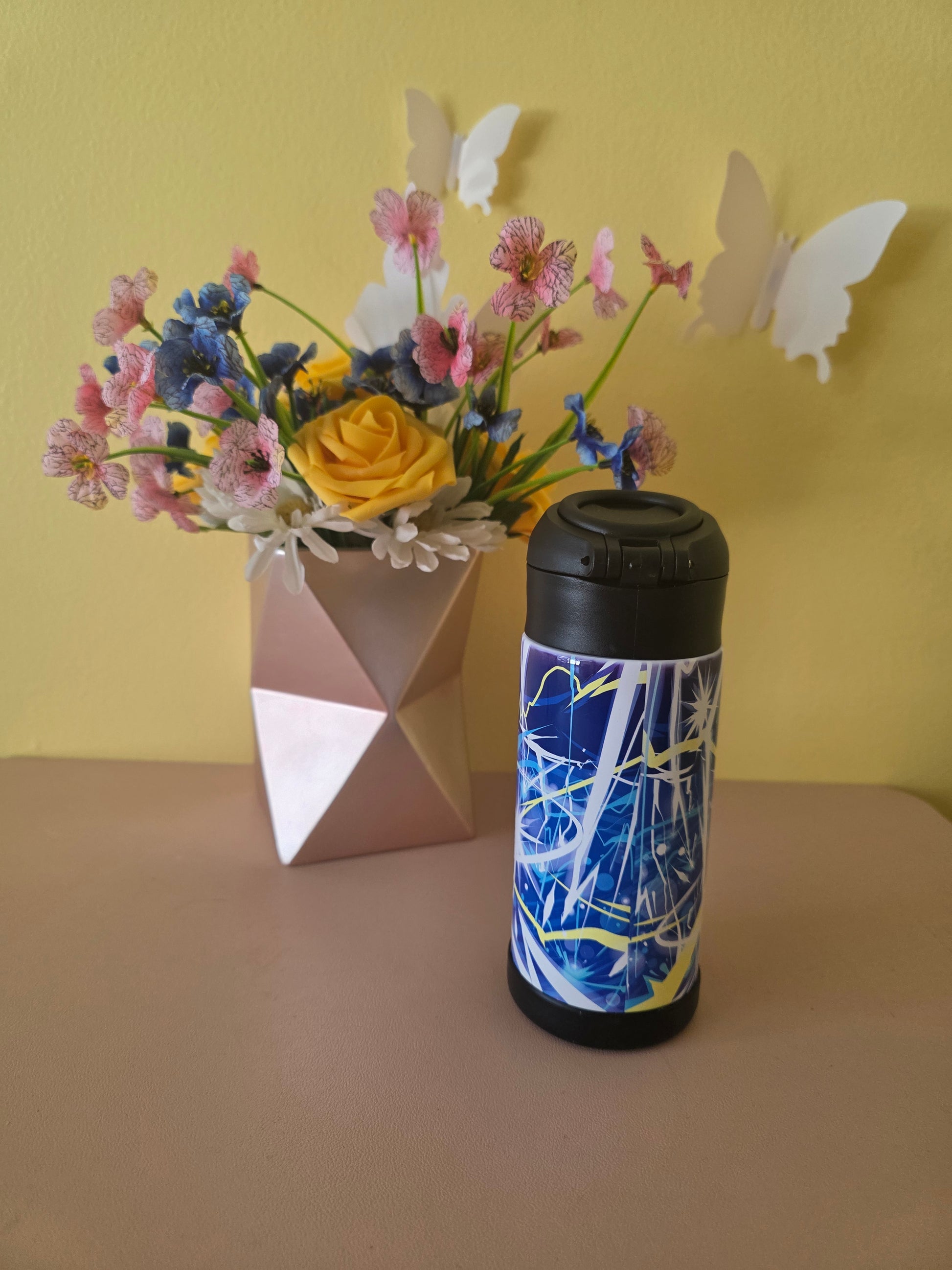 Pokemon Pikachu water bottle on a table with flowers in the background