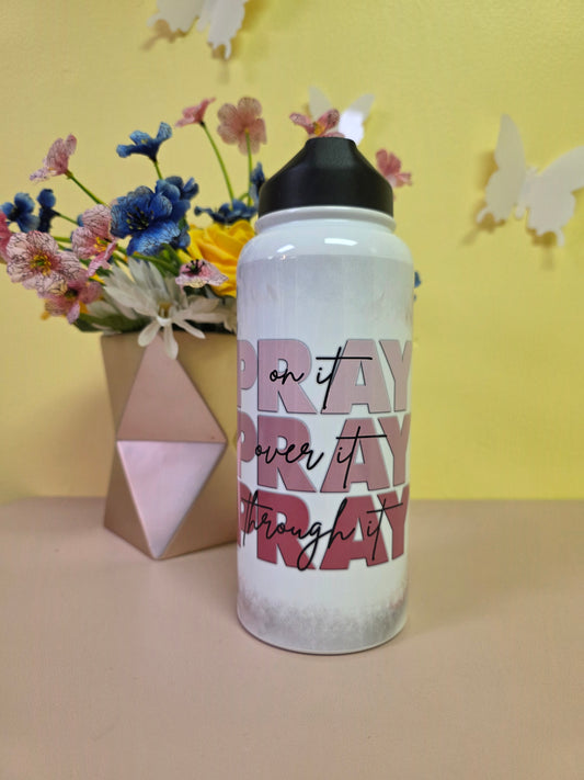 Water bottle with a prayer design on a table with yellow background. 