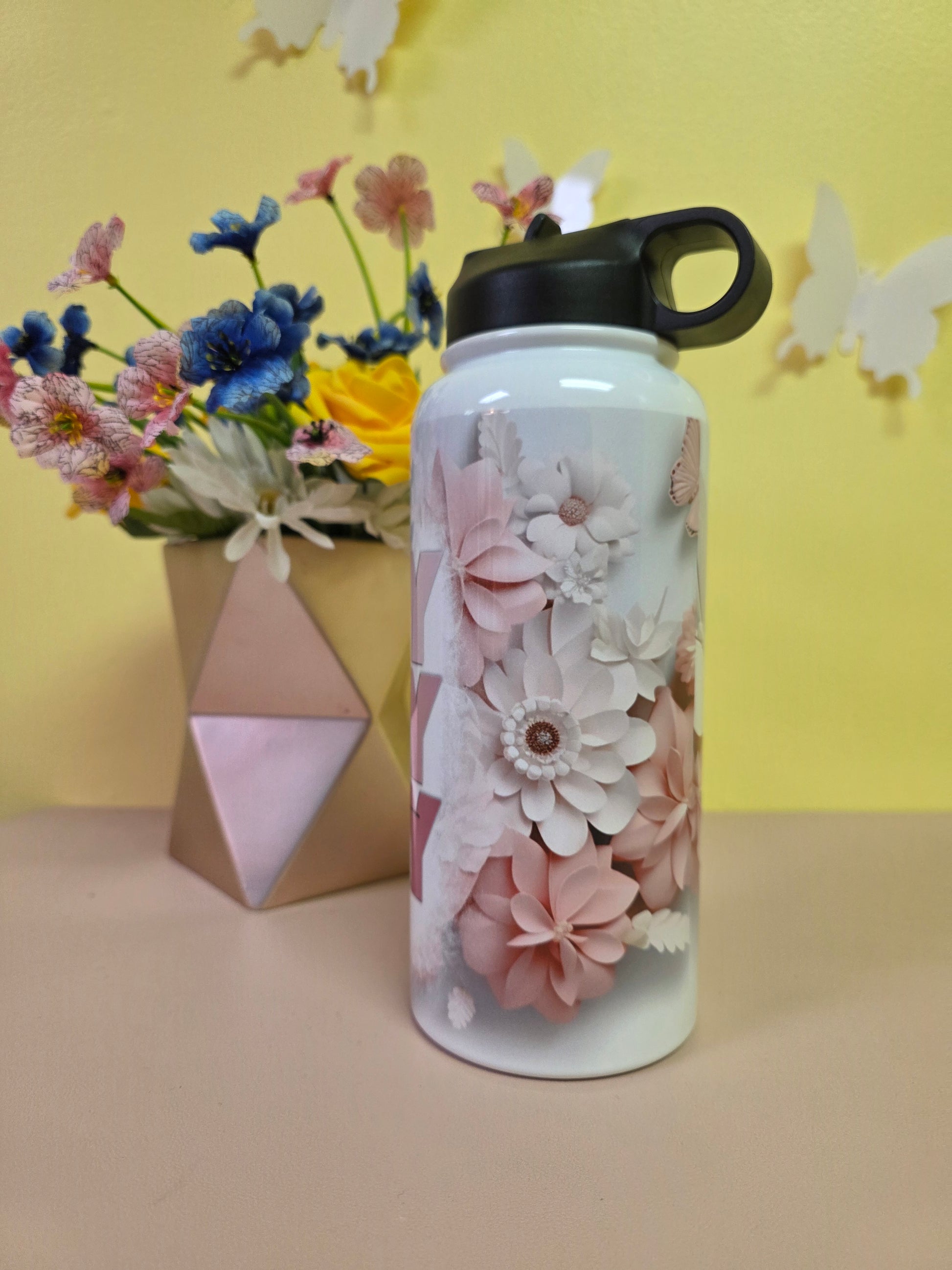 Water bottle with a prayer design on a table with yellow background. 