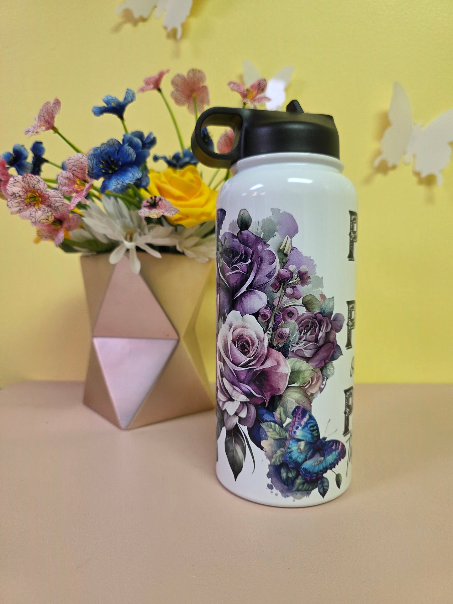 Water bottle with 'PRAY' text on a yellow background with flowers