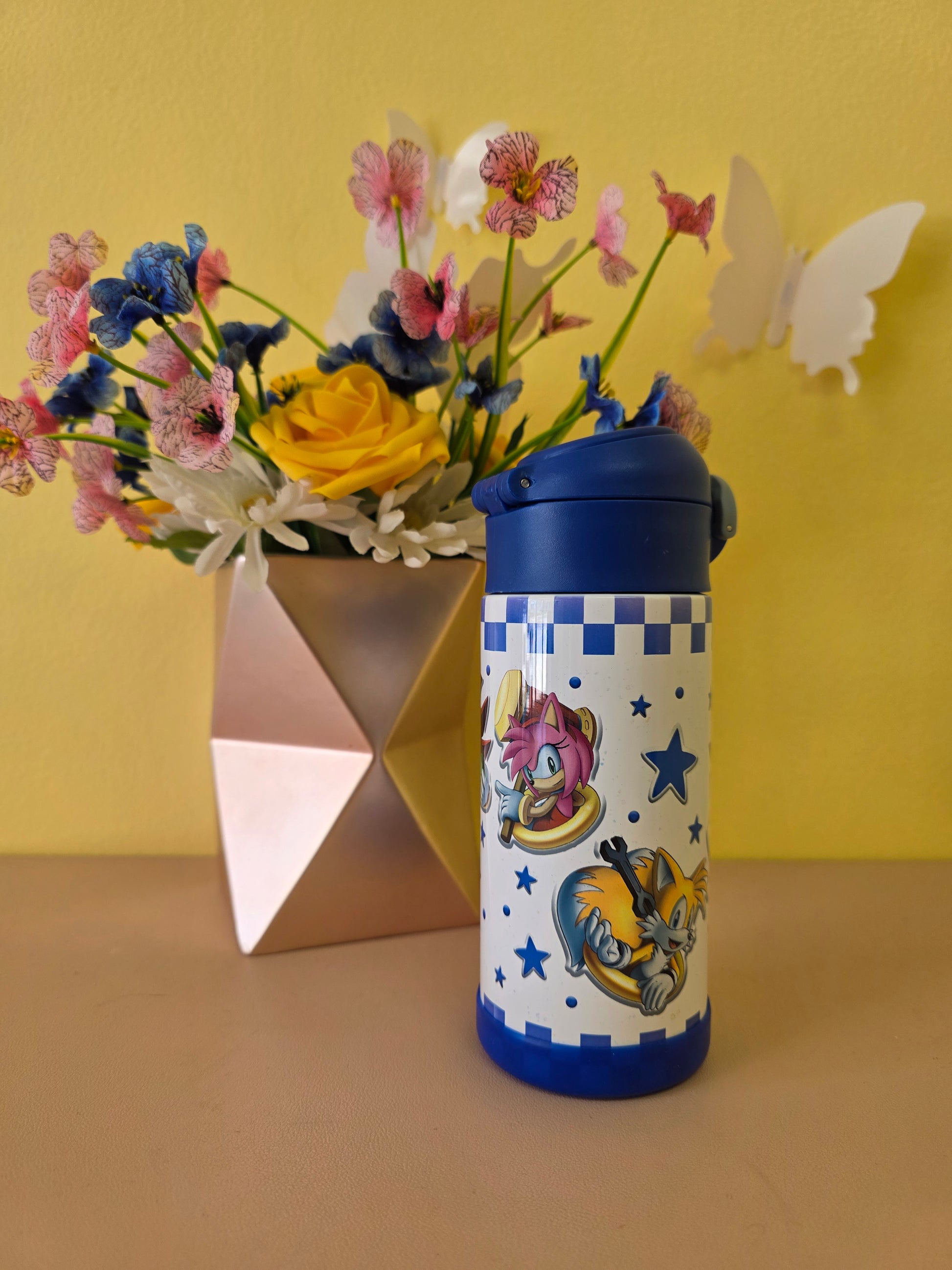 Colorful water bottle with cartoon design on a yellow background