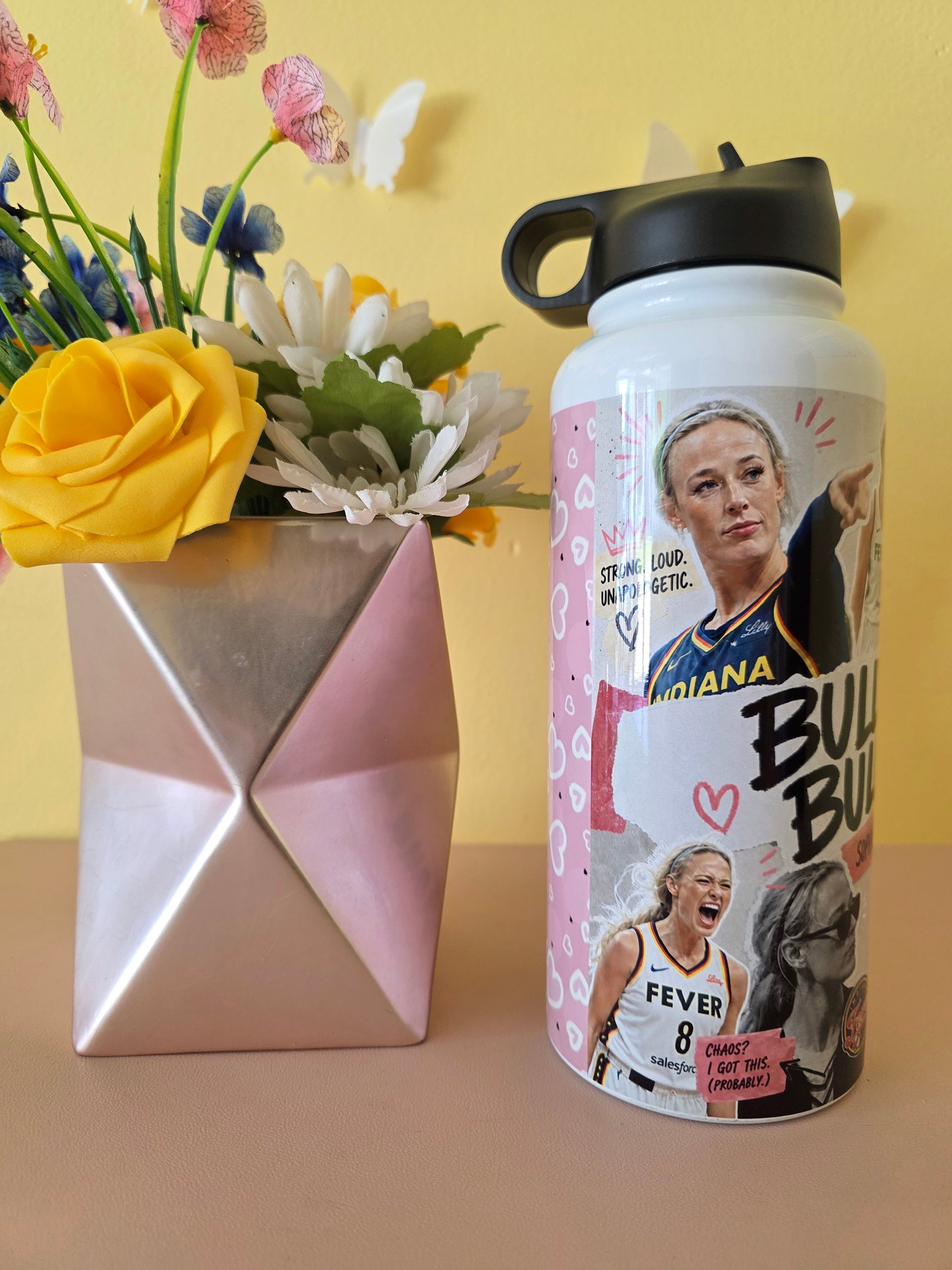 Custom women’s basketball collage water bottle with inspirational quotes displayed beside a geometric vase and yellow rose