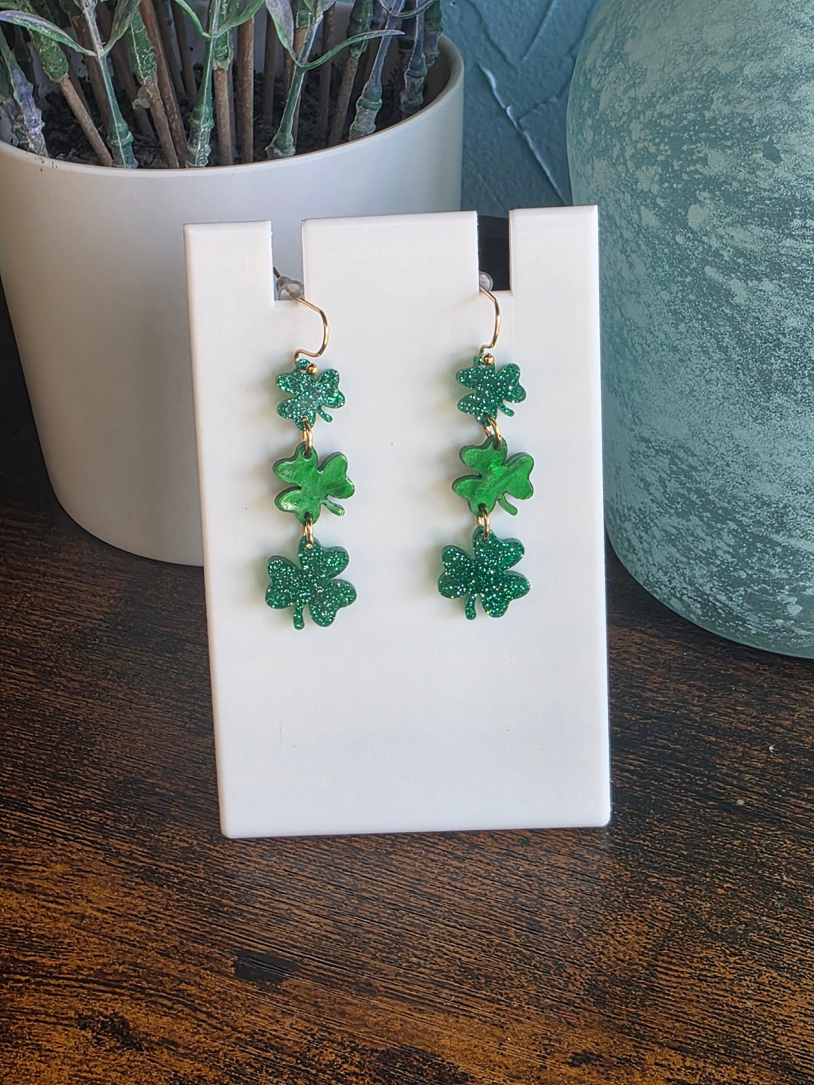 Green glitter earrings with three shamrock dangles for St. Patrick's Day.