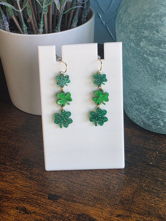 Green glitter earrings with three shamrock dangles for St. Patrick's Day.