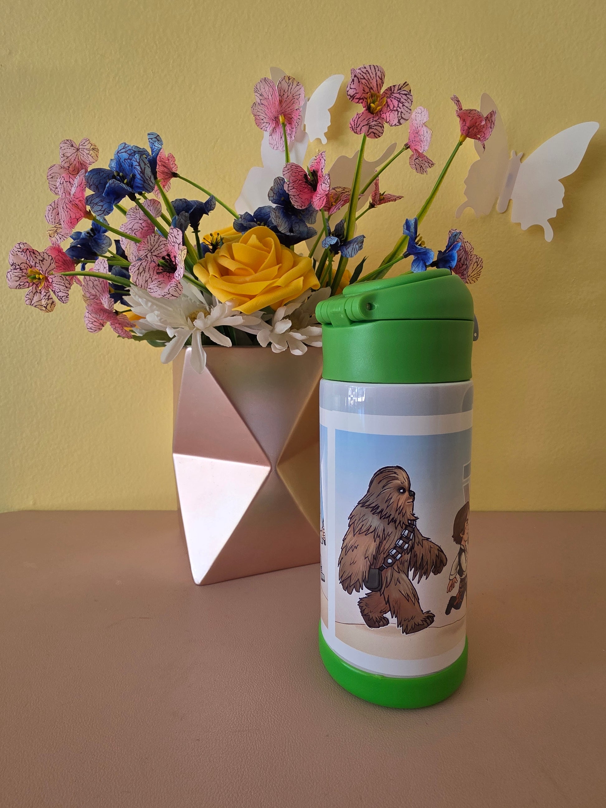 Star Wars kids tumbler on a table with flowers in the background. 