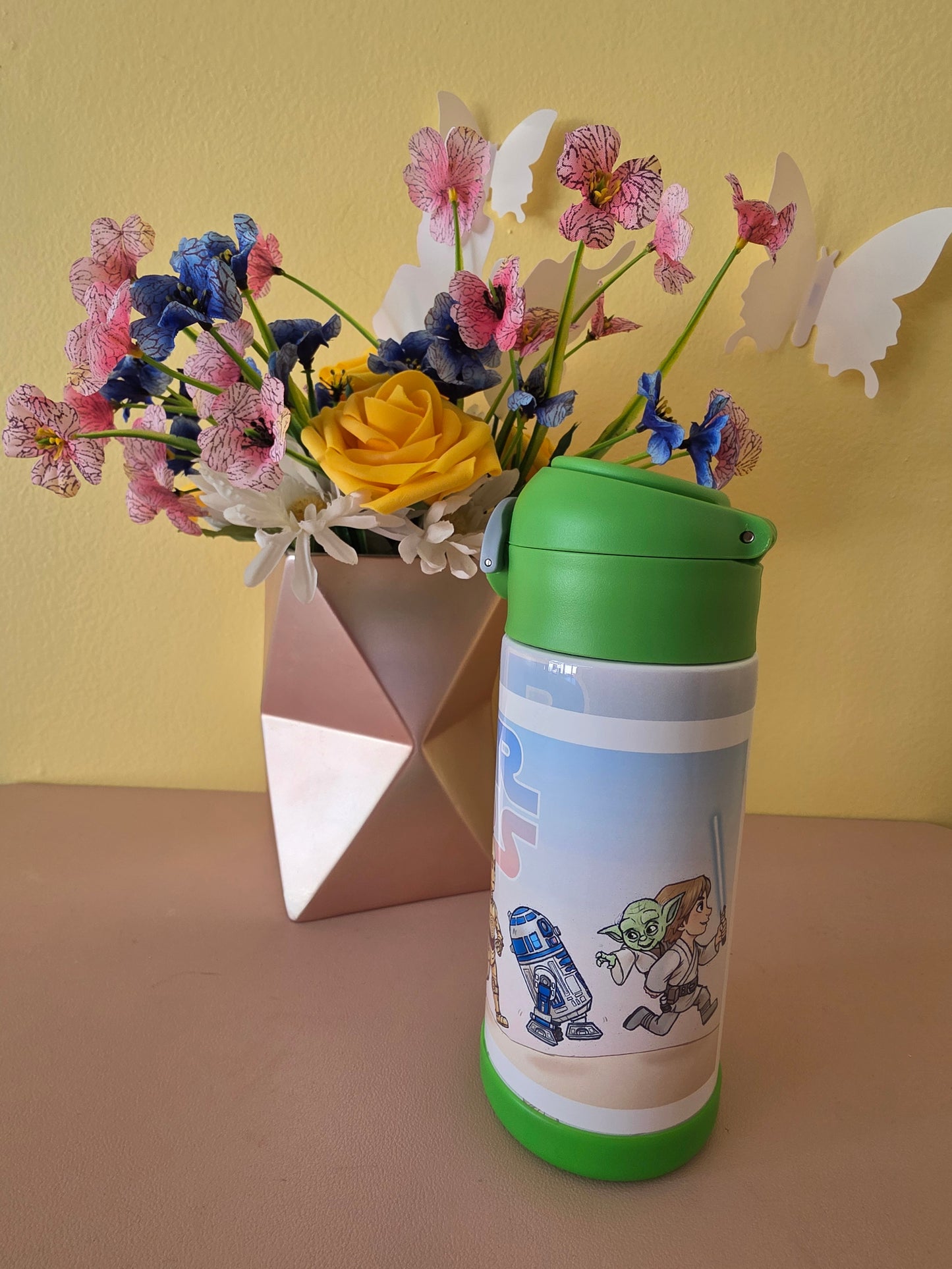Star Wars kids tumbler on a table with flowers in the background. 