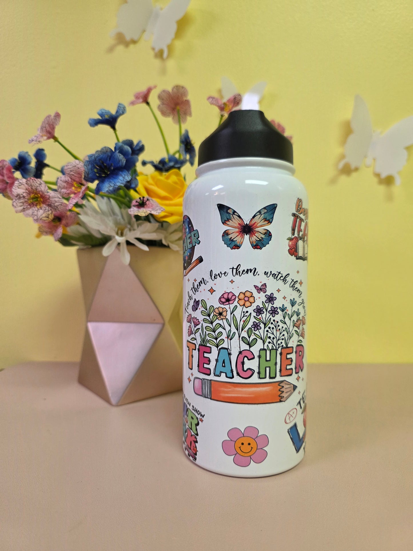 Decorative water bottle with colorful designs on a yellow background