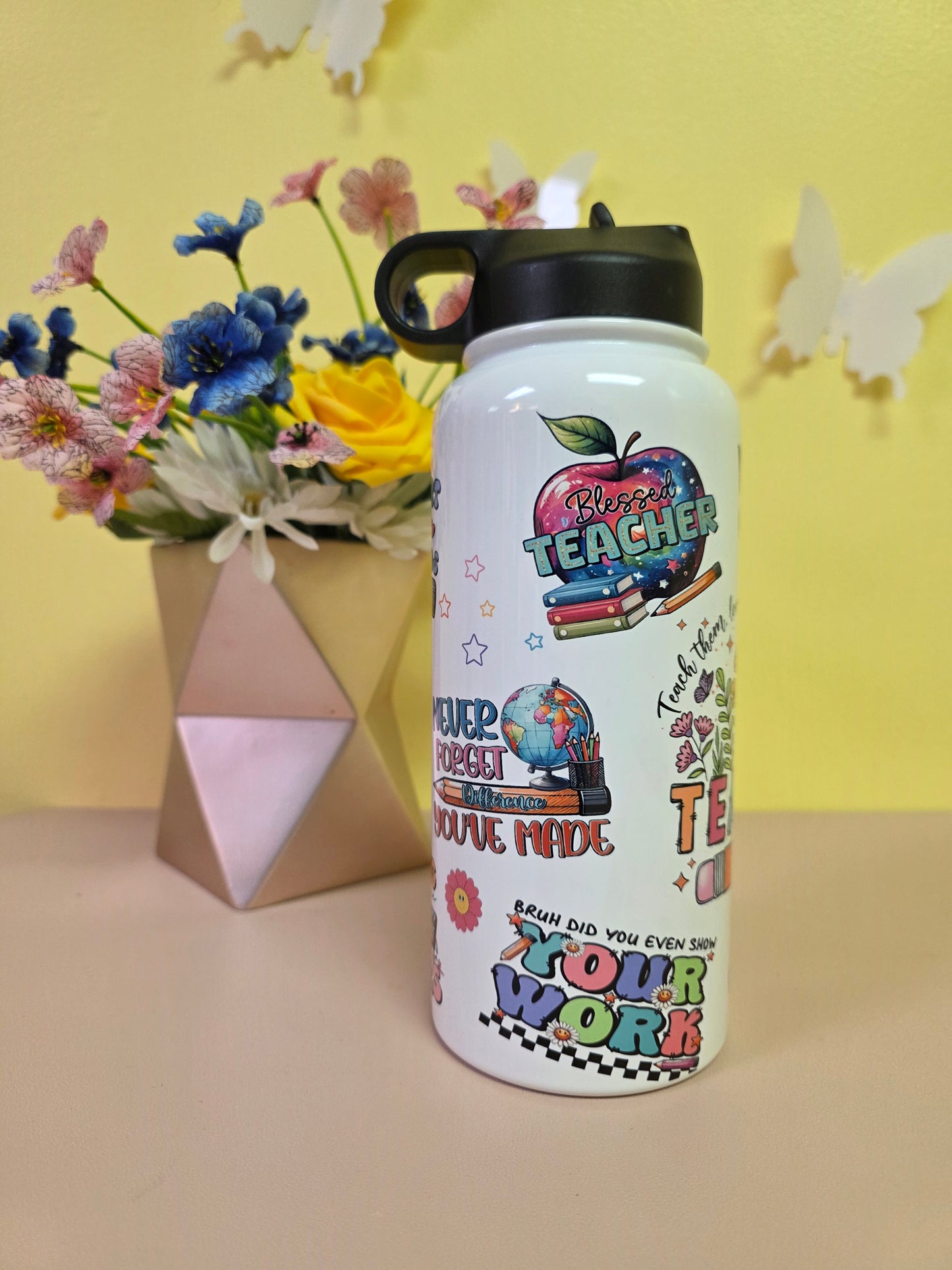 Colorful water bottle with text and graphics on a yellow background with flowers and a box.
